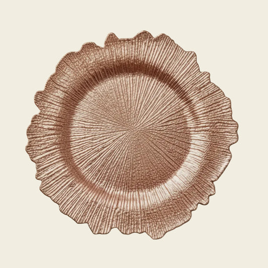 A collage showing two textured scalloped plates: one in metallic rose gold and one in metallic silver, with one plate styled on a table setting next to a white dinner plate, silverware, and a wine glass.