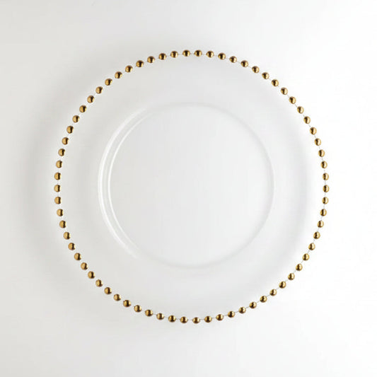 A white round plate with a delicate border of small metallic gold beads, photographed from directly above on a clean white background.