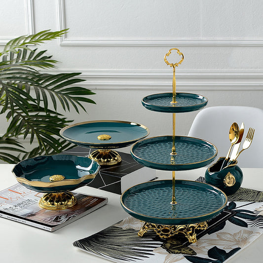 Emerald green three-tier cake stand with gold trim on a stainless steel frame