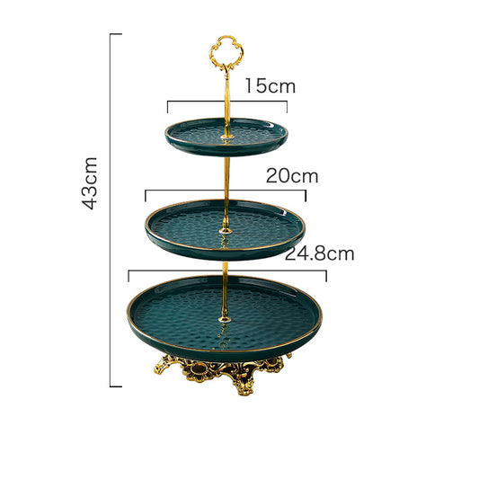 Emerald green three-tier cake stand with gold trim on a stainless steel frame